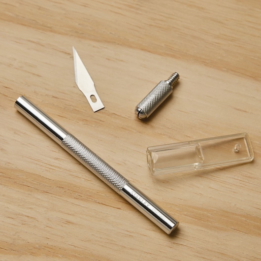 Stanley 10-401 precision knife with blade, metal handle, and clear plastic cap on wood surface