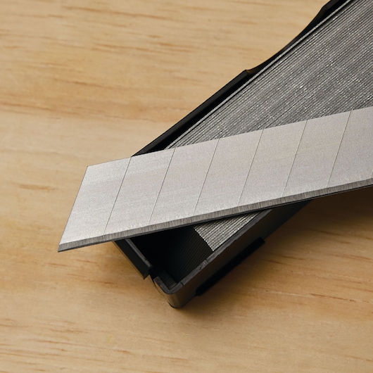 STANLEY SKU 11-301L utility knife replacement blades in black plastic case on wood surface.