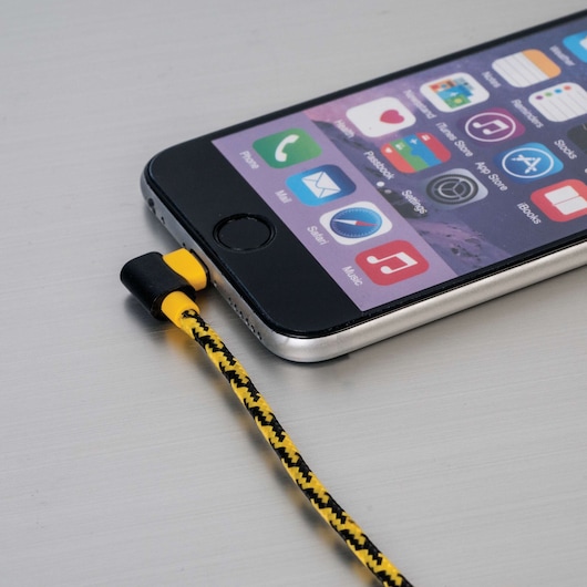 STANLEY 1311724ST2 braided yellow and black charging cable connected to smartphone, close-up angle.