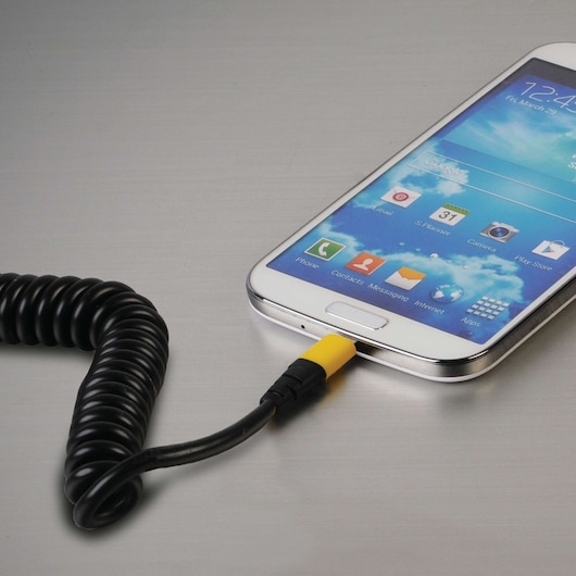 STANLEY 1319552ST2 photography of black coiled charging cable with yellow tip plugged into smartphone, angled view.