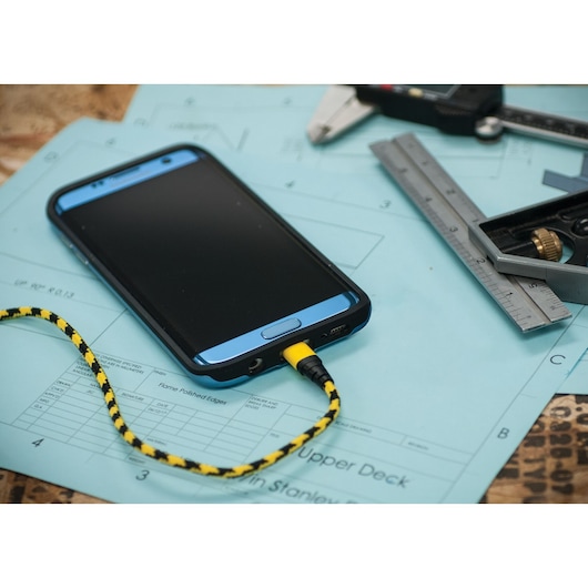 STANLEY 1319562ST2 braided yellow and black USB cable plugged into smartphone, shown with technical drawings and caliper.