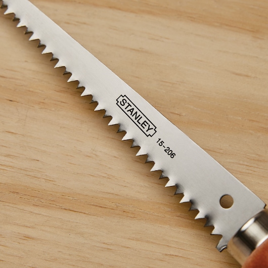 STANLEY 15-206 saw blade with sharp teeth, close-up on wood surface.