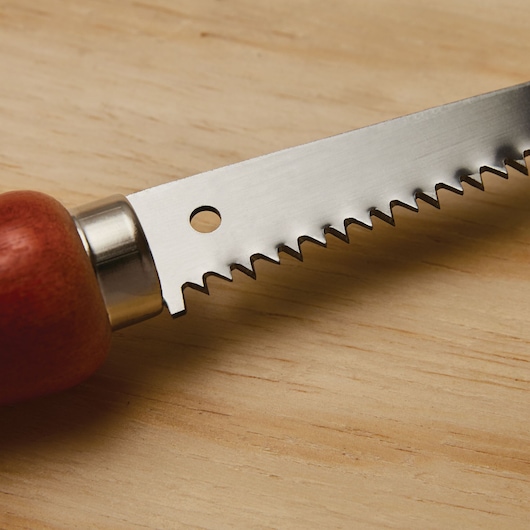 STANLEY 15-206 hand saw close-up, showing sharp steel blade with wooden handle on light wood surface.