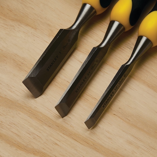 STANLEY 16-300 woodworking chisel set with yellow and black handles on wood surface.
