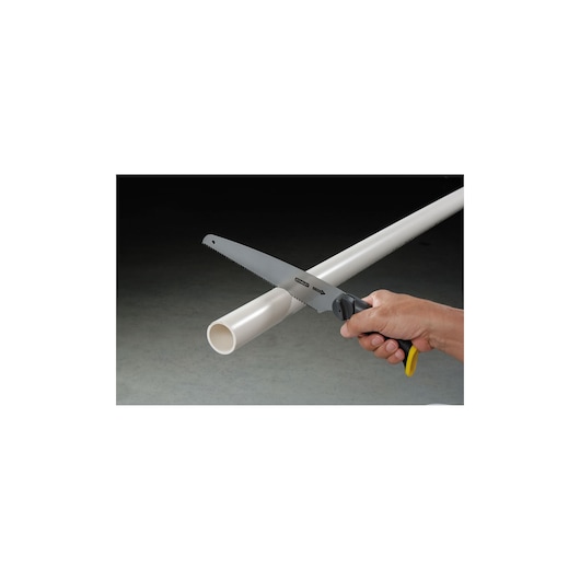 Photo of STANLEY 20-092 hand saw cutting white PVC pipe, close-up view.