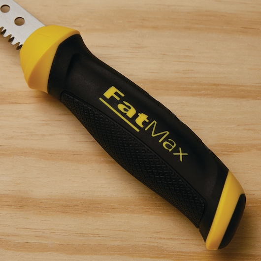 STANLEY FatMax 20-556 hand saw handle with black and yellow rubber grip, close-up view on wood surface.