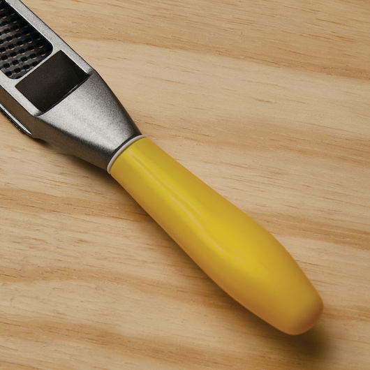 STANLEY 21-295 hand rasp with yellow handle, close-up on wood surface.