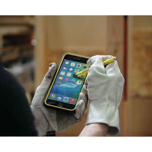 Photo of STANLEY 2151049ST2 stylus pen used on smartphone screen by person wearing work gloves.