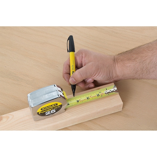 STANLEY 33-425 tape measure marking wood, close-up of measurement in use on a wooden surface.