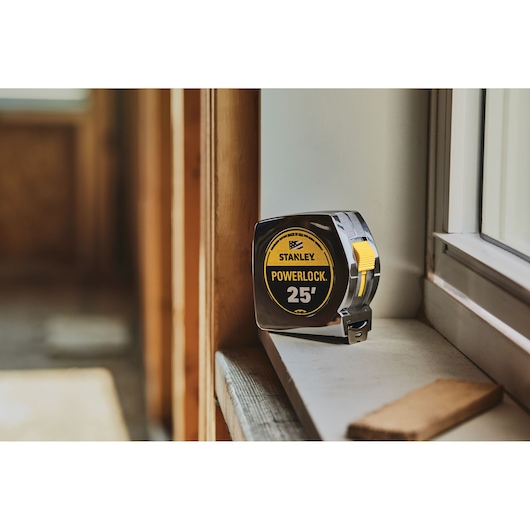 STANLEY 33-425 tape measure with yellow and black label on windowsill, product category: photography.