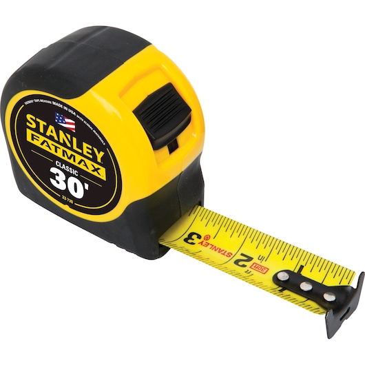 Angled view of STANLEY FATMAX 30-foot classic tape measure with yellow and black casing, extended yellow blade