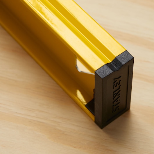 Photo of STANLEY 42-324 yellow level tool with black end cap, close-up on wood surface.