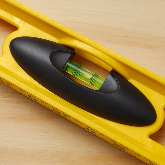 STANLEY 42-468 yellow level tool with black handle, close-up of horizontal vial on wooden surface.