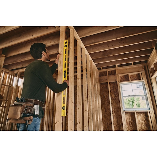 STANLEY 42-470 level tool in use on wooden framing, indoor construction, side angle.