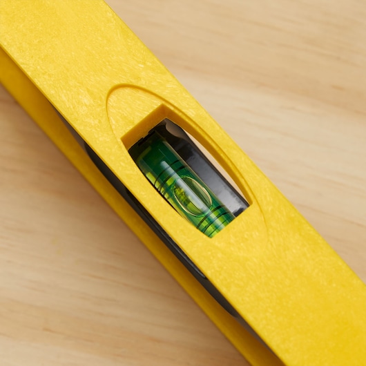 STANLEY 42-470 yellow level tool close-up showing vial on wooden surface.