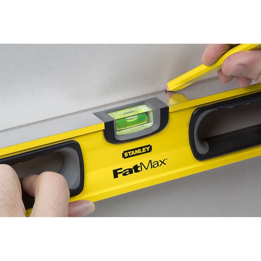 STANLEY 43-524 FatMax level photography, yellow tool with bubble vial, close-up in use.