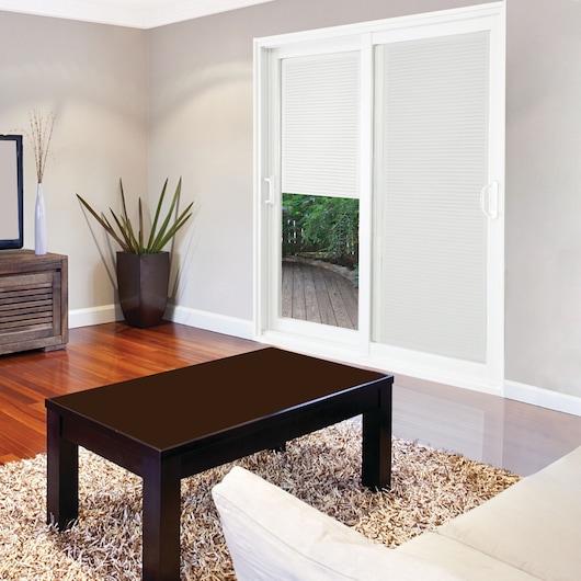 STANLEY 500004 photography of a modern living room with wood table, light rug, TV stand, and sliding patio door.