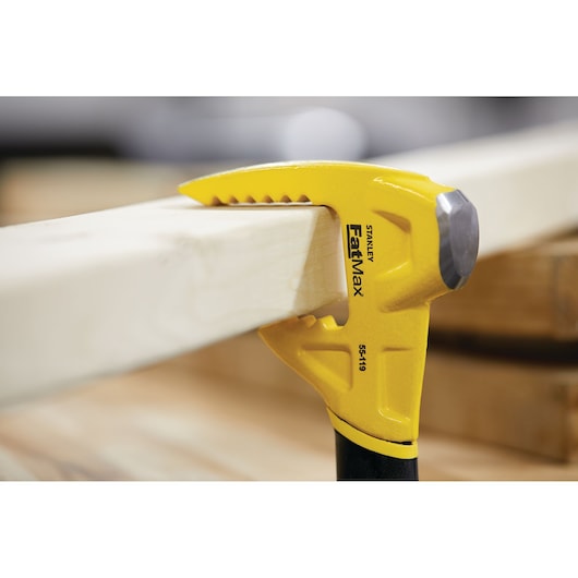 STANLEY 55-119 yellow FatMax demolition tool gripping wooden beam, close-up side view.