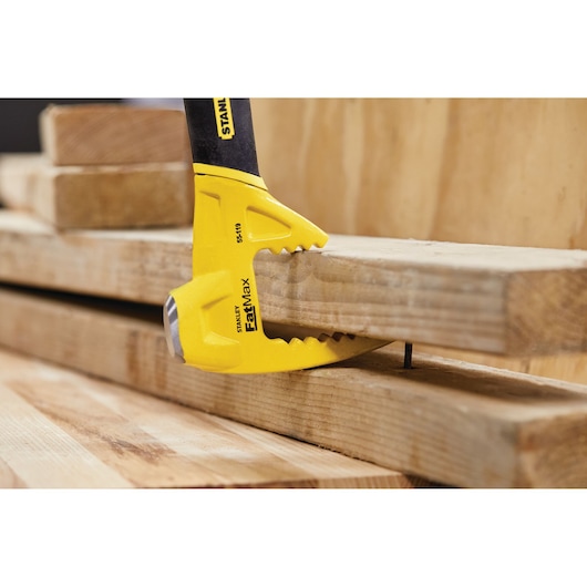 STANLEY 55-119 FatMax wrecking bar prying wood with claw end, close-up view.