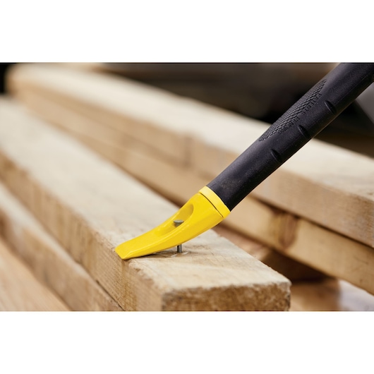 STANLEY 55-119 yellow and black pry bar removing nail from wood, close-up side view.