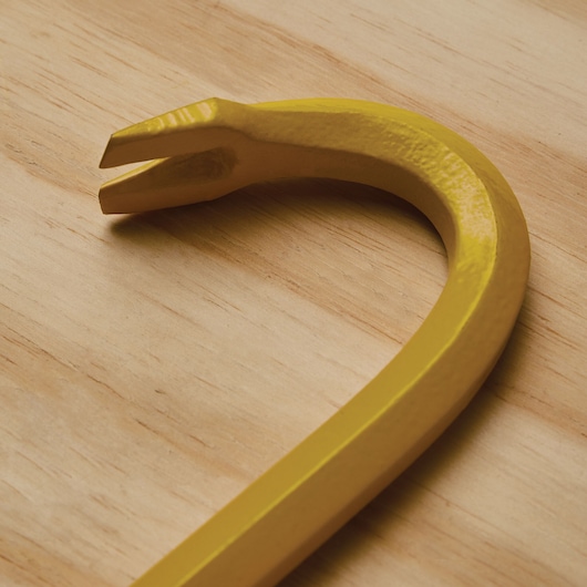 STANLEY 55-136 yellow curved claw bar photographed on wood surface, close-up of prying end.