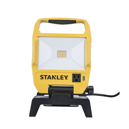 Front view, STANLEY portable LED work light with yellow housing, power outlet, and USB port on white background