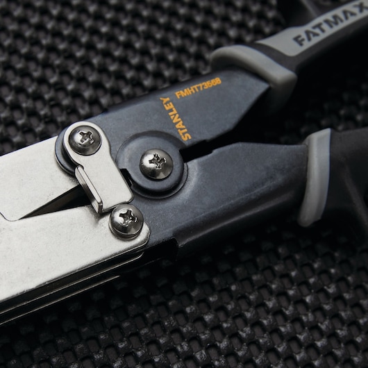 STANLEY FMHT73568 aviation snip with black and silver finish, close-up of joint and blade on textured surface.