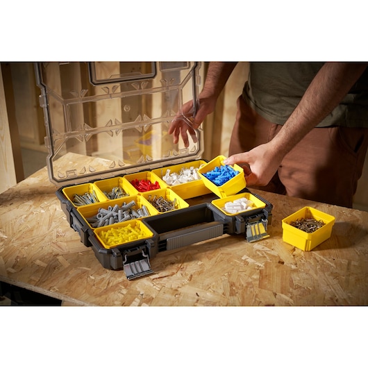 STANLEY FMST14820 organizer with yellow removable bins filled with hardware, shown on a workbench, angled view.