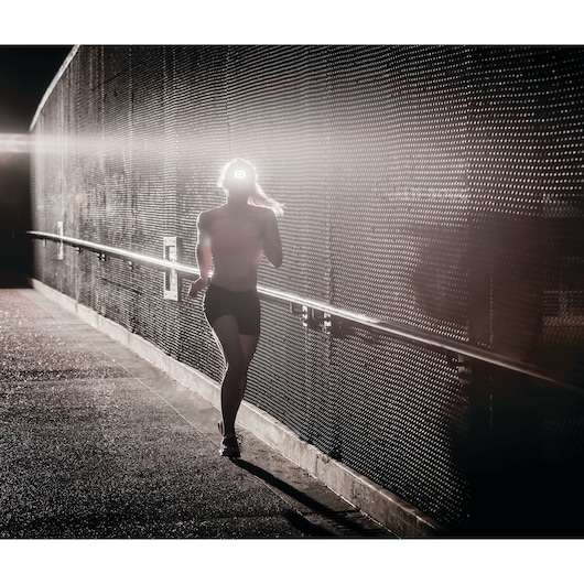 STANLEY HBHL1S photography showing a person jogging at sunrise with backlight highlighting headlamp on urban path.