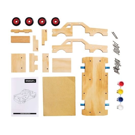 Stanley toy truck wood assembly kit, flat lay, with wheels, paint, screws, and instructions on white background