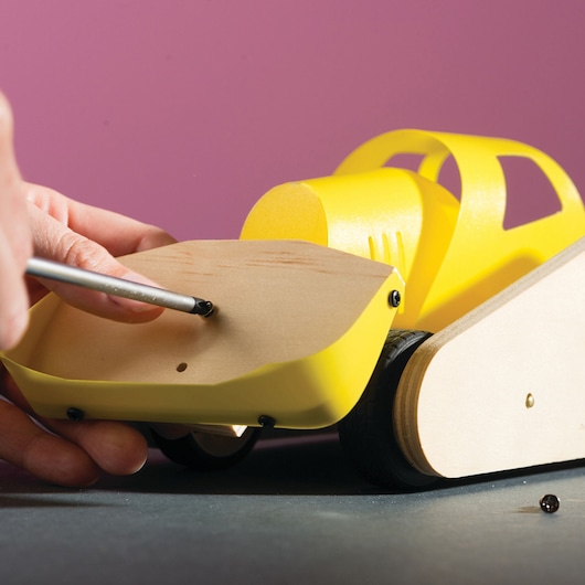 STANLEY OK005-SY assembly of yellow wooden toy car with screwdriver, shown from side angle.