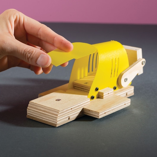STANLEY OK005-SY photography of wooden and yellow plastic model with hand lifting yellow cover.