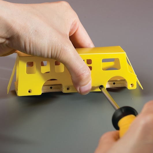 STANLEY OK015-SY screwdriver assembling a small yellow model vehicle, close-up angle.