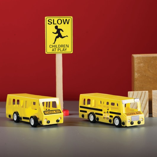 STANLEY OK015-SY photography of yellow toy school buses and 'Children at Play' sign shown front angle.