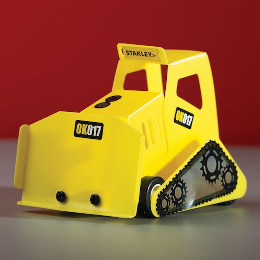 STANLEY OK017-SY yellow toy bulldozer side view with gear design on black tracks and visible brand logos.