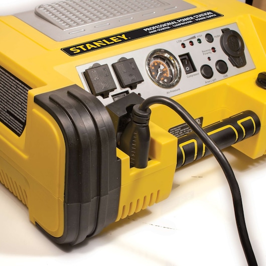 Photo of STANLEY PPRH5 yellow portable power station with control panel, outlets, gauge, and attached black cable, angled view.