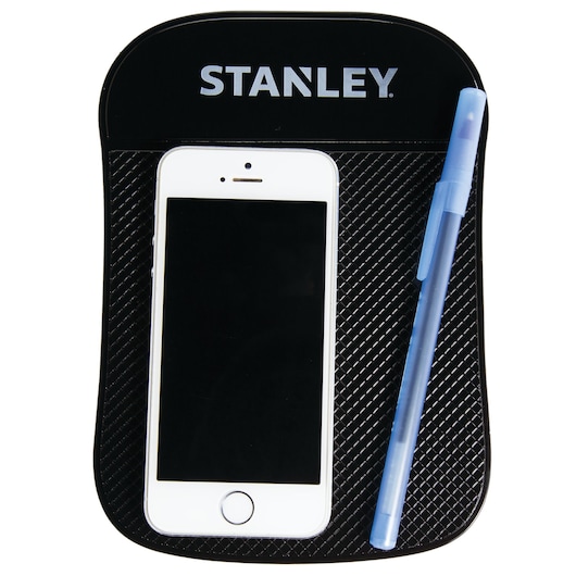 Photo of STANLEY S4006 black dashboard pad holding a smartphone and blue pen, top view, product photography.
