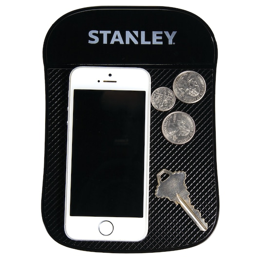 STANLEY S4006 black anti-slip dashboard pad holding a phone, coins, and a key, top view on white background.