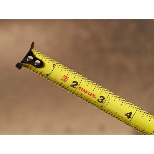 STANLEY STHT37242 yellow tape measure with black hook and inch markings, side angle.