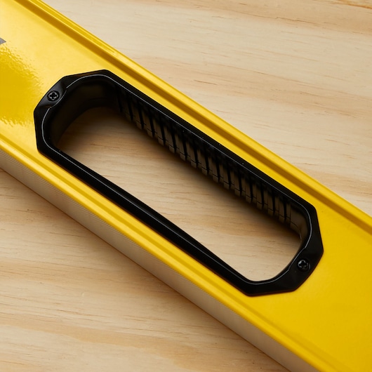 STANLEY STHT42504 level handle, yellow body with black grip, close-up on wood surface.