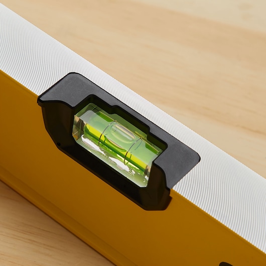 STANLEY STHT42504 box beam level, yellow body with horizontal vial, close-up photo on wood surface.