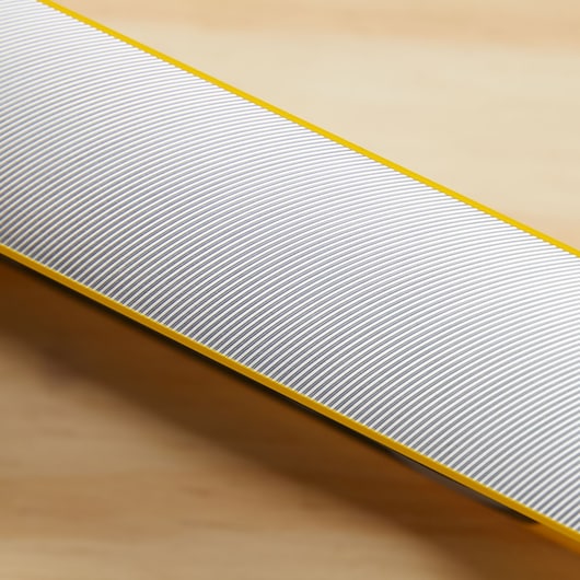 STANLEY STHT42504 metal file with fine horizontal grooved texture and yellow edge, close-up angle.
