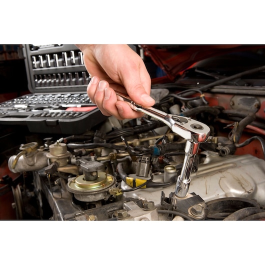 STANLEY STMT71654 socket wrench in use, automotive repair scene, tool kit visible in background.
