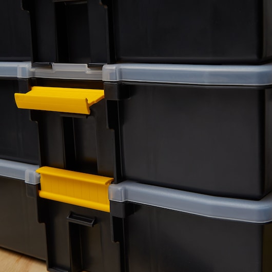 STANLEY STST14027 black storage boxes with yellow latches, close-up photo of stacked containers.