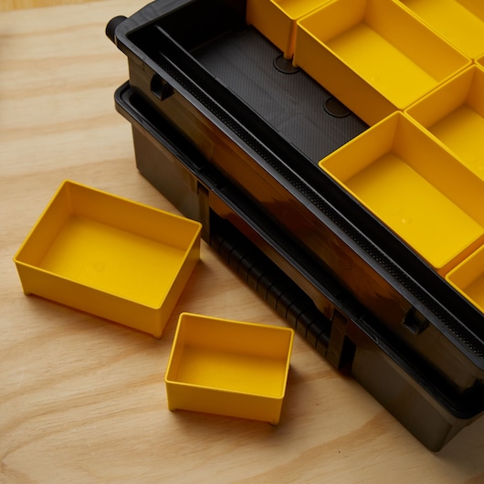 Stanley STST14028 photography of black toolbox with removable yellow storage bins on wood surface.
