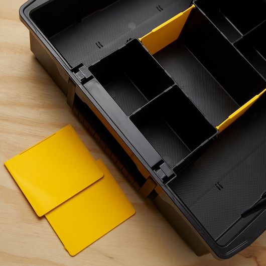 STANLEY STST14028 black tool organizer with removable yellow dividers, top view on wooden surface.