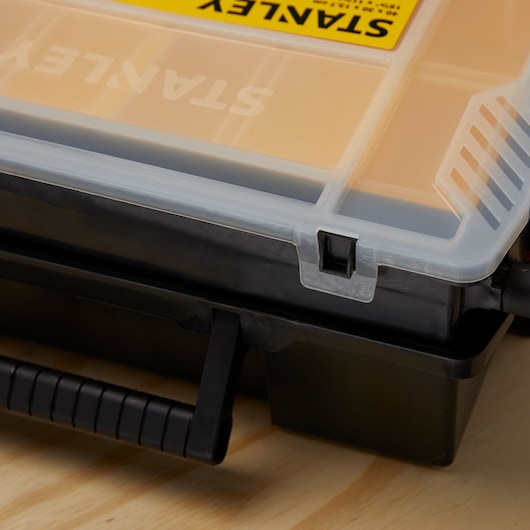 STANLEY STST14028 organizer box close-up showing latch and black handle on wooden surface.