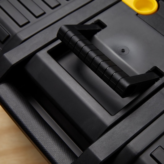 STANLEY STST18613 photography of black plastic toolbox handle, close-up view, textured grip detailing.
