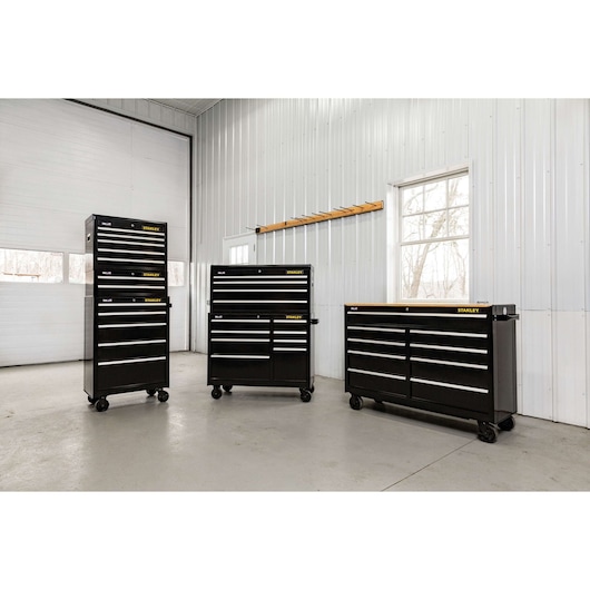 STANLEY STST22657BK black rolling tool chests with multiple drawers in a garage, straight-on angle.