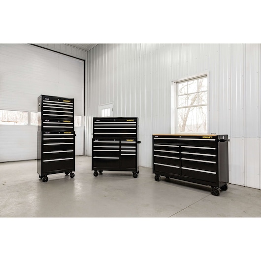 STANLEY STST22753BK black tool chests with drawers on wheels in workshop, front angle.